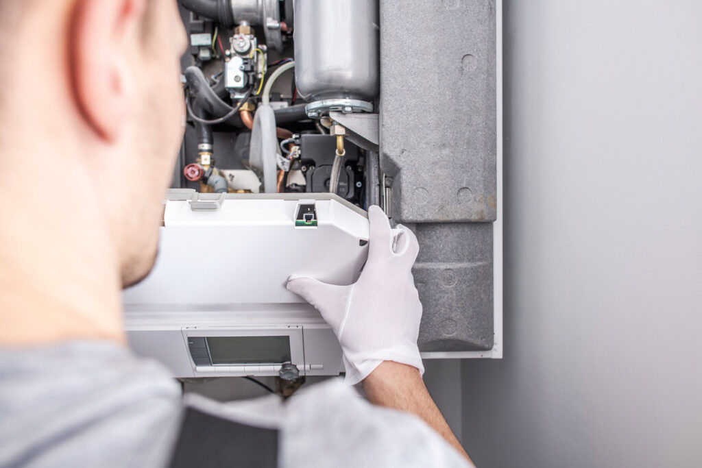 Close-up of tech fixing central heating furnace system.